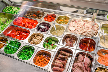 Showcase salad bar with an assortment of ingredients for healthy and dietary food. Salad take away. High quality photo