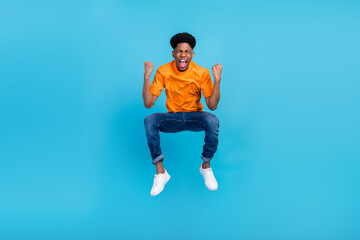 Fototapeta na wymiar Full length body size view of attractive cheerful guy jumping having fun success isolated over bright blue color background