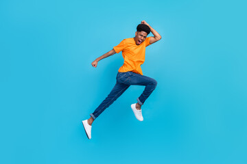 Fototapeta na wymiar Full length body size view of attractive cheerful funky guy jumping running fast isolated over bright blue color background