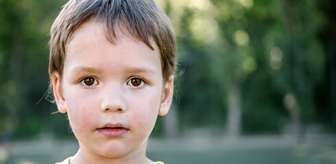 A cute little boy in yellow T-shirt in the football field