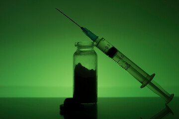 The syringe is on a test tube with medicine. 