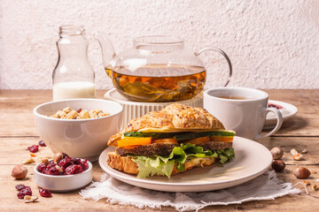 Healthy breakfast concept. Morning good mood with tea, croissant, granola, milk, and jam