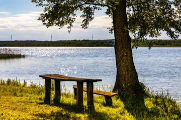 Panoramic summer view of Jezioro Selmet Wielki lake landscape with camping pier and wooded island in Sedki village in Masuria region of Poland