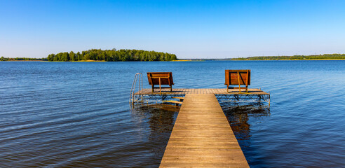 Panoramic summer view of Jezioro Selmet Wielki lake landscape with recreation pier in Sedki village in Masuria region of Poland - obrazy, fototapety, plakaty