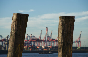 Harbor cranes behind wooden bollard