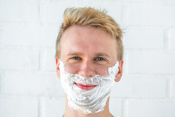 A young man with shaving foam on his face