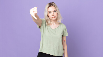 pretty albino woman feeling cross, angry, annoyed, disappointed or displeased, showing thumbs down...