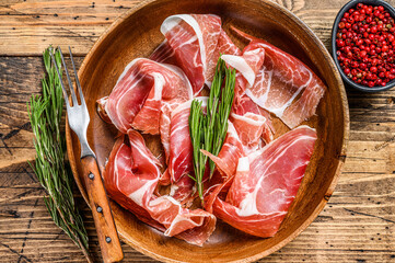 Spanish sliced Jamon Serrano pork ham. wooden background. Top view