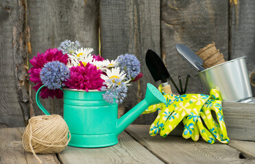 Gardening tools with flowers on a wooden background. Gardening concept, garden center. Image with selective focus