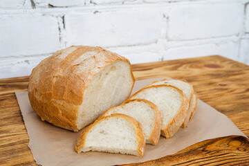 white yeast bread on a wooden table. gluten-free product made from wheat flour. delicious fresh organic pastries.