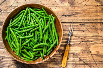 Cooked green beans in a wooden plate. wooden background. top view. Copy space