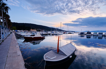 Wooden boat in sea marina at sunset time.