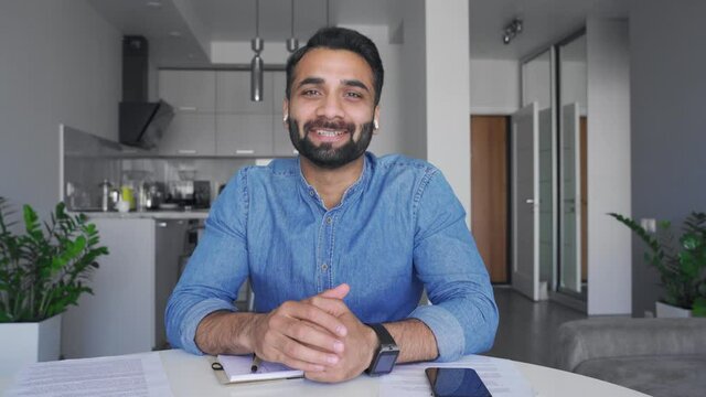 Confident Smiling Indian Man In Earphones Making Video Conference Call