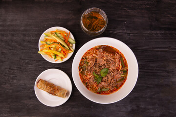 rice noodle soup with beef slices, spring roll, salad and tea