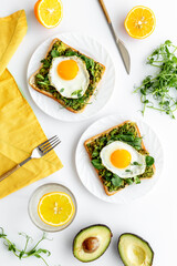 Toasts with avocado and fried eggs. Healthy breakfast