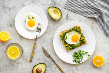 Eggs and avocado with spinach on toasted bread. Top view