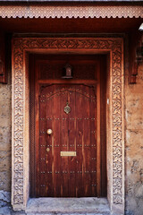 Ancient stone wall of old building with wooden vintage door.