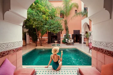Poster Retreat and vacation. Beautiful young woman relaxing in spa private swimming pool in beautiful moroccan backyard. © luengo_ua