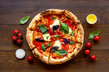 Homemade pizza margarita with tomatoes and basil on the table