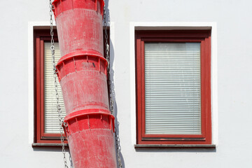 Rotes Fallrohr für Bauschutt an der Fassade eines Hauses, Deutschland, Europa