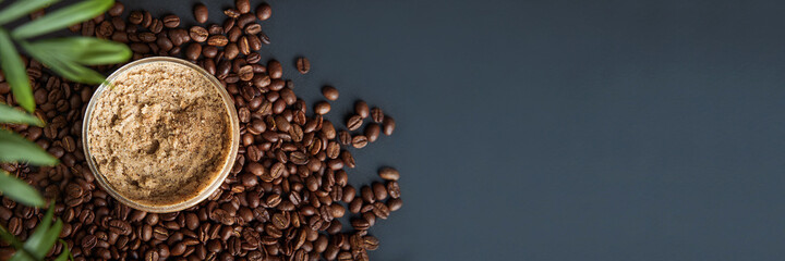 Coffee body scrub and coffee beans on dark background banner. Skincare, health care concept.