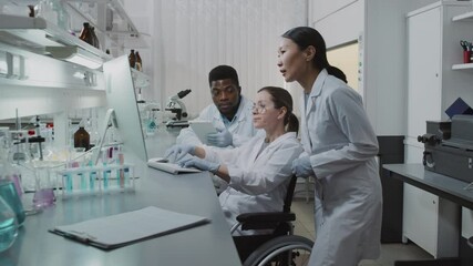 Slowmo tracking shot of diverse team of scientists looking at computer screen and discussing research in lab - Powered by Adobe