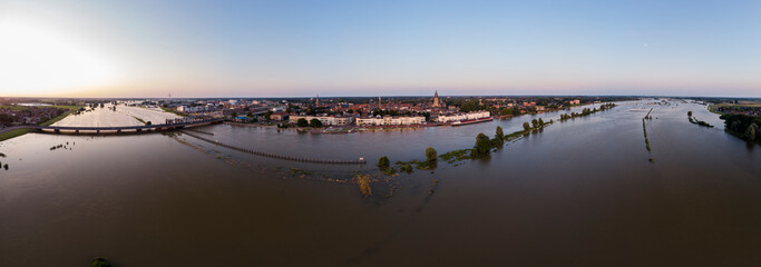 Aerial wide panorama of Dutch landscape with floodplains overflown of the river IJssel with Zutphen, The Netherlands, on the horizon. Climate and weather condition concept.