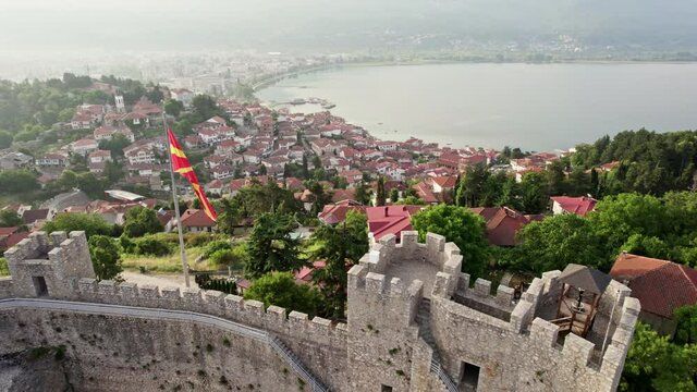Ohrid fortress Samoils Fortress with flag of North Macedonia waving on the wind. Aerial view of resort town of Ohrid with a magnificent lake