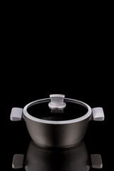 Moscow, Russia - 07/26/2020:
Pot company Gipfel, with rubber handles, with a glass lid on a black background