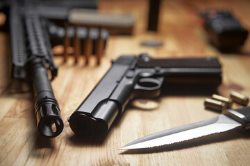 Guns with ammunition on wooden background.