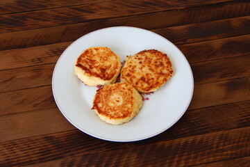 Homemade cheesecakes on a plate on the dark wooden background