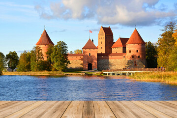 Empty wooden table and view of medieval gothic Trakai island castle - obrazy, fototapety, plakaty