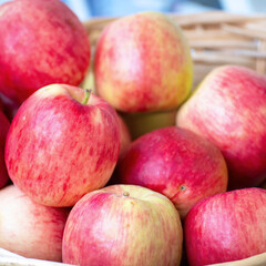Red ripe apples in a wicker basket. Selective focus