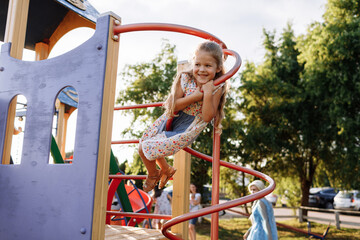 Fototapeta na wymiar Young boy, kid or child playing outdoors on playground.