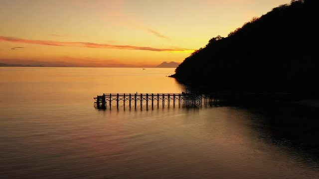 Aerial drone footage of the sunset over a jetty of a remote island off Labuan Bajo in Flores, Indonesia