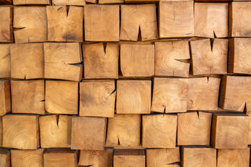 Wooden, textured wall lined with wooden cubes, longitudinal cuts of a fir tree. Top view.