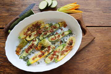 Fried zucchini stuffed with minced meat, cheese and bacon on wooden background