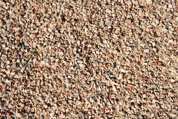 The surface is covered with small stones of white, pink, gray colors.