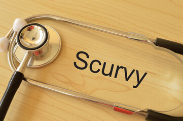 Stethoscope on the table with text SCURVY. Scurvy is a deficiency disease that results from lack of...