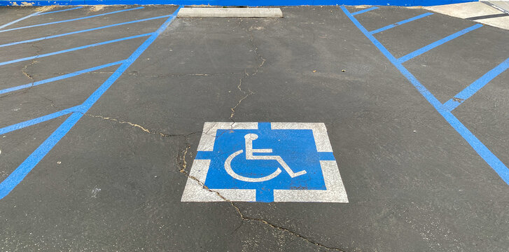 blue and white disabled driver handicap wheelchair symbol parking space for car park on asphalt