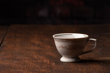 Porcelain cup, beautiful porcelain cup arranged on rustic wood, dark background, selective focus.