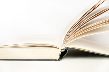 Open hardcover book on white background. Educational concept