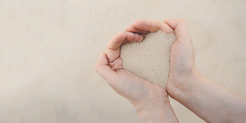 Women's hands hold white beach sand.