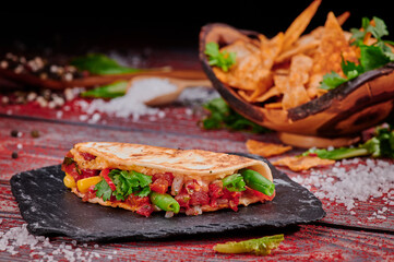 Crispy tacos with salsa on a wooden red background. Mexican food and fast food. High quality photo