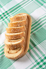 Rocambole, Sliced ​​rocambole stuffed with dulce de leche on a wooden tray on a table with checkered tablecloth. dark background, selective focus.
