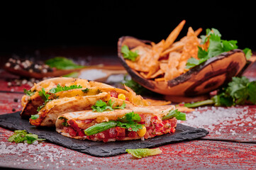 Crispy tacos with salsa on a wooden red background. Mexican food and fast food. High quality photo