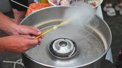 The process of making cotton candy on the street.