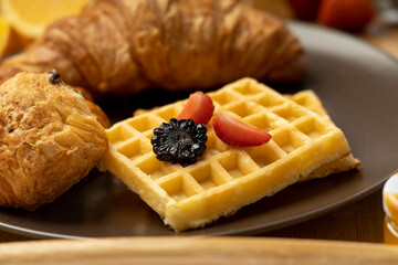 Breakfast in a tray filled with black Coffee, Cheese and chocolate croissant with orange juice with few strawberries