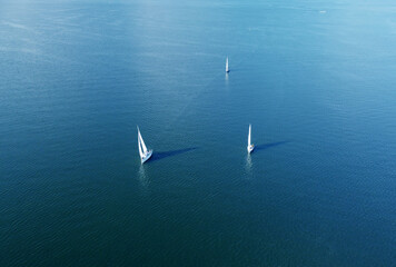 Aerial view of white yachts with sail. Ships in the blue sea