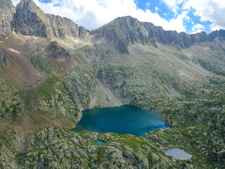 Aerial view of a wild lake in the middle of the high mountains of pyrenees.